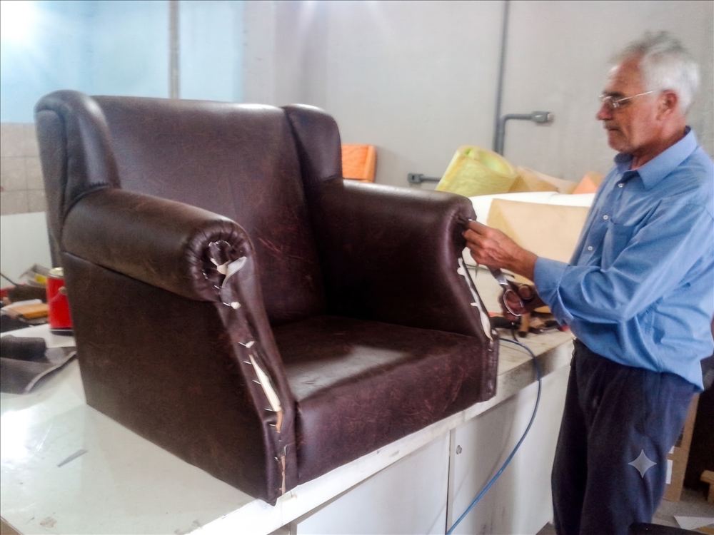 Poltrona de couro sendo reformada na bancada da oficina